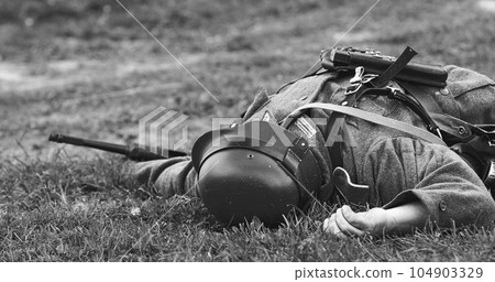 Close Up View On Re-enactor Dressed As German Wehrmacht Soldier Lies Slain In Reconstruction Of Battles World War Ii. German Infantry Soldier In World War Ii. Reconstruction. Black And White 104903329
