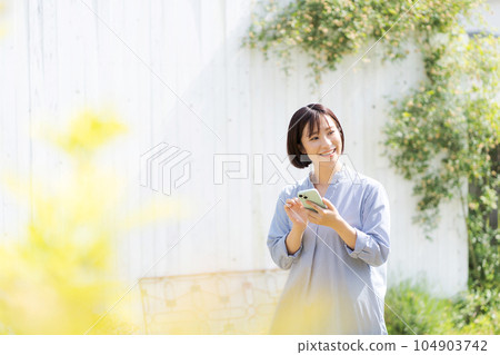 一個三十多歲的女人，拿著手機 104903742