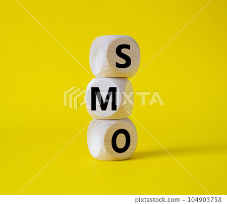 SMO - Social Media Optimization symbol. Wooden blocks with words SMO. Beautiful yellow background. Business and SMO concept. Copy space. 104903758