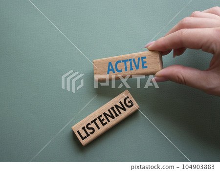 Active listening symbol. Wooden blocks with words Active listening. Businessman hand. Beautiful grey green background. Business and Active listening concept. Copy space. 104903883