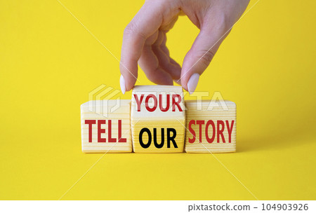 Tell Your or Our story symbol. Businessman hand turns wooden cubes and changes the words Tell Our story to Tell Your story. Beautiful yellow background. Business concept. Copy space 104903926