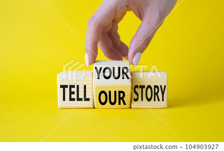 Tell Your or Our story symbol. Businessman hand turns wooden cubes and changes the words Tell Our story to Tell Your story. Beautiful yellow background. Business concept. Copy space 104903927