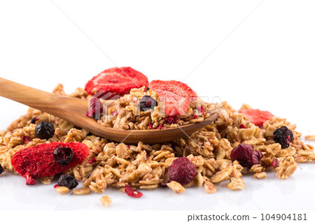 Muesli oat cereals close up background with dry fruits in wooden spoon 104904181