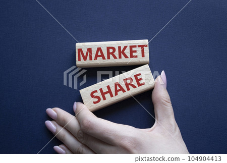 Market Share symbol. Wooden blocks with words Market Sharer. Beautiful deep blue background. Businessman hand. Business and Market Share concept. Copy space. 104904413