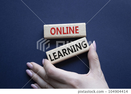 Online learning symbol. Wooden blocks with words Online learning. Beautiful deep blue background. Businessman hand. Business and Online learning concept. Copy space. 104904414
