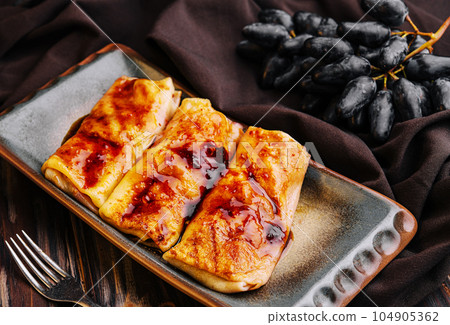 Pancakes with strawberry jam on plate 104905362