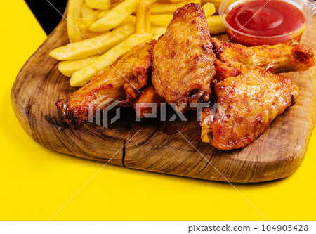 Breaded crispy fried chicken wings, french fries and sauce 104905428