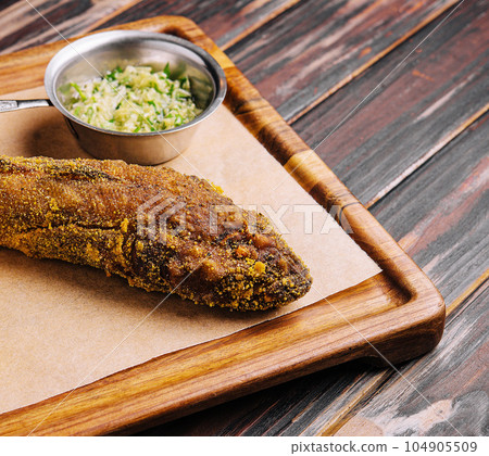 fried fish on wooden board with spicy sauce fried fish on wooden board with spicy sauce 104905509