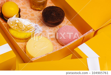 Christmas gifts presents with different cakes on yellow background Christmas gifts presents with different cakes on yellow background 104905761