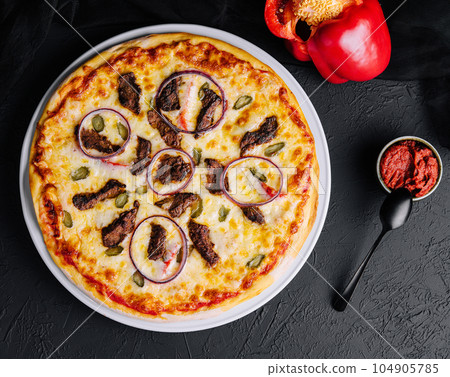 italian pizza with tomatoes, cheese, onions on black italian pizza with tomatoes, cheese, onions on black 104905785