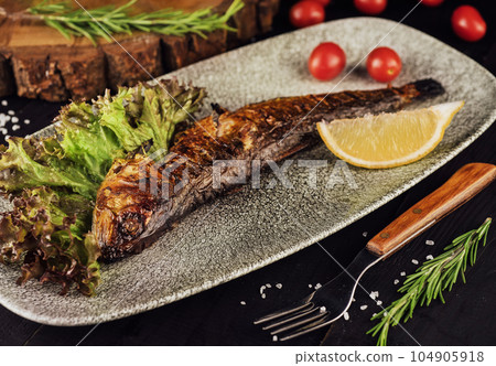 Fish dish - grilled herrings with cherry tomatoes 104905918