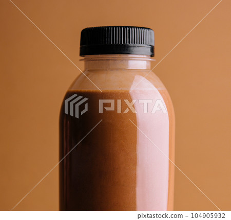 Brown smoothies in a bottle on a brown background 104905932
