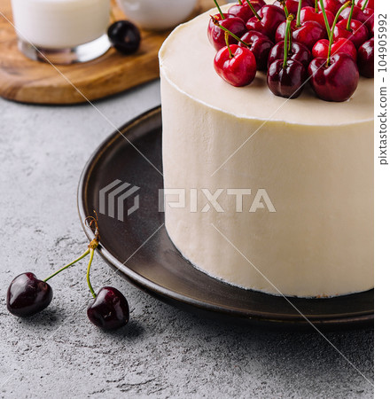 vanilla cheesecake mousse with cherries on black plate 104905992