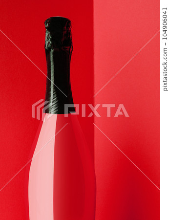 Red bottle of champagne on yellow background 104906041