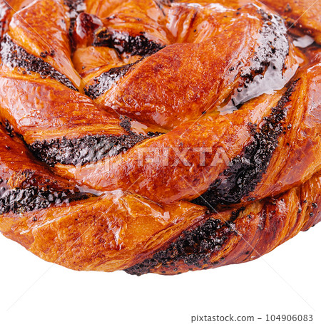 Round sweet twisted bun made with puff pastry with grated poppy seeds 104906083