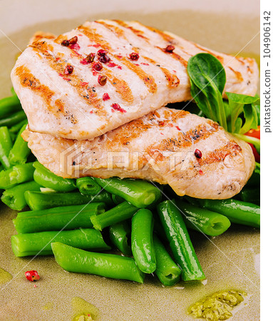 Grilled chicken fillets on green beans 104906142