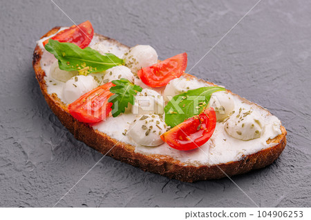Caprese bruschetta toasts with cherry tomatoes 104906253