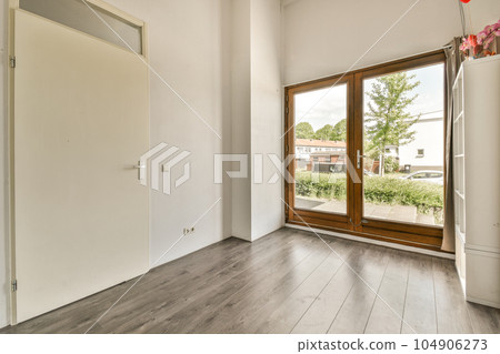 an empty room with wood flooring and sliding glass door that leads to the outside patio, which has been painted white an empty room with wood flooring and sliding glass door that leads to the outside patio, which has been painted white 104906273