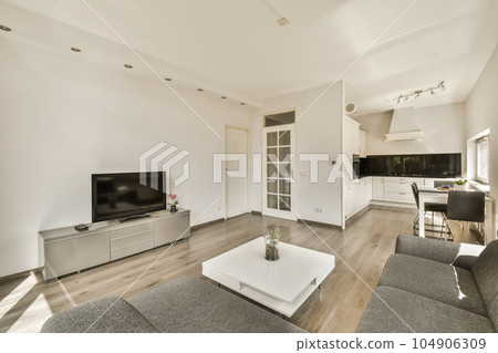 a living room with white walls and wood flooring, including a large flat screen tv mounted on the wall a living room with white walls and wood flooring, including a large flat screen tv mounted on the wall 104906309