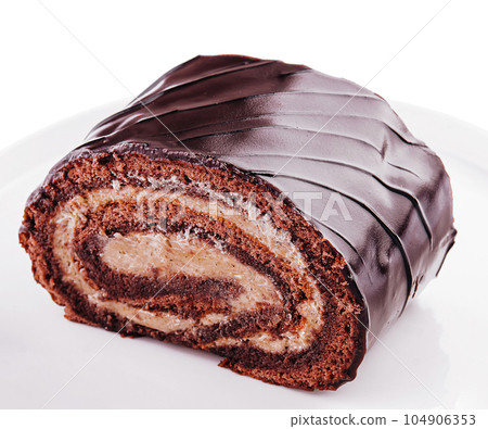 Chocolate roll with cream on a white plate 104906353