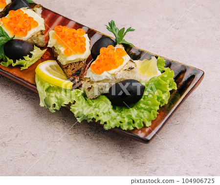 Bruschetta with red caviar on a plate 104906725