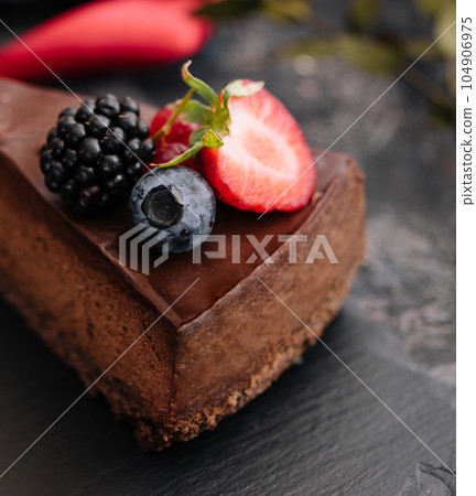 Delicious chocolate cake decorated with fresh berries on wooden table 104906975