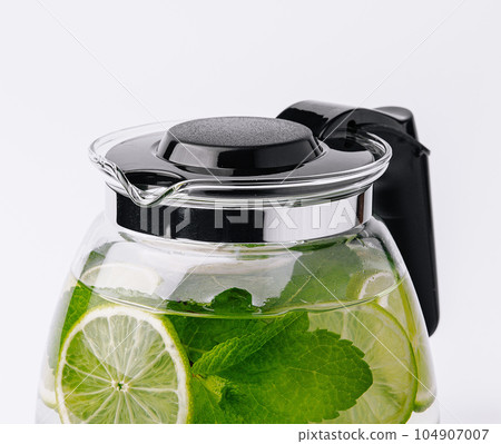 Fruit water with lime and mint in glass pitcher Fruit water with lime and mint in glass pitcher 104907007