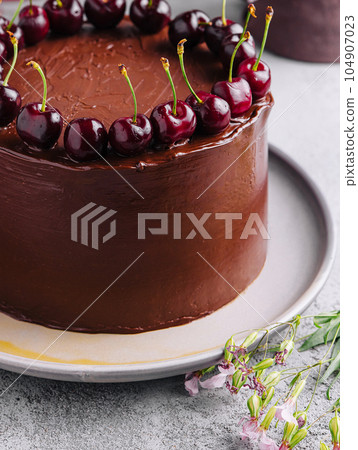 Chocolate cake decorated with sweet cherries 104907023