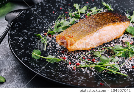 Salmon steak roasted on black plate Salmon steak roasted on black plate 104907041