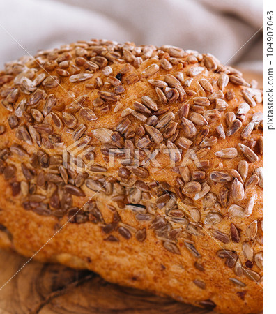 Whole wheat bread with seeds on wood Whole wheat bread with seeds on wood 104907043