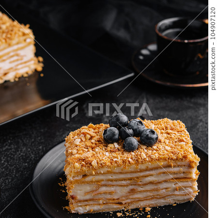 cake napoleon with blue blueberries and tea cup 104907120