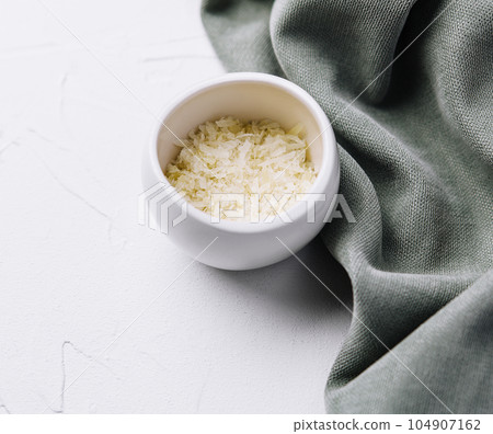 Grated aged italian parmesan cheese in white bowl Grated aged italian parmesan cheese in white bowl 104907162