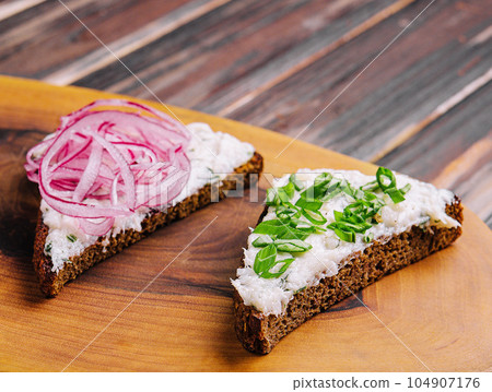 pieces of bread with delicious lard with red and green onions 104907176