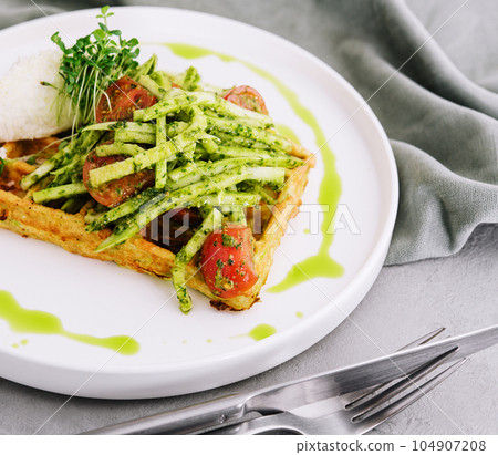 Closeup of tasty vegan potato waffle with pesto and fresh natural vegetables 104907208