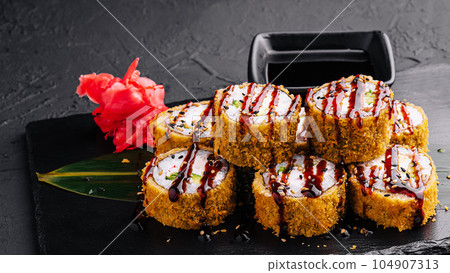 Served warm sushi with ginger and wasabi on a black stone plate Served warm sushi with ginger and wasabi on a black stone plate 104907313