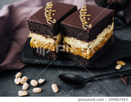 Fluffy snickers cake on stone board Fluffy snickers cake on stone board 104907463