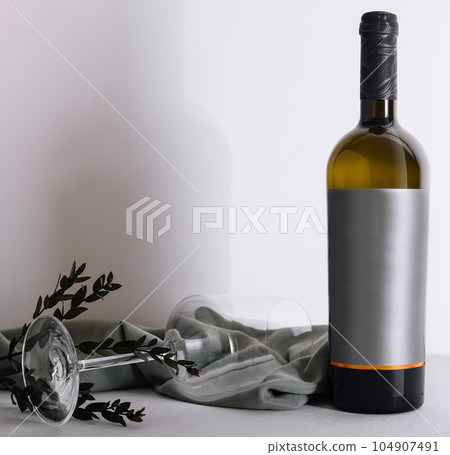 glass and bottle of wine on white 104907491