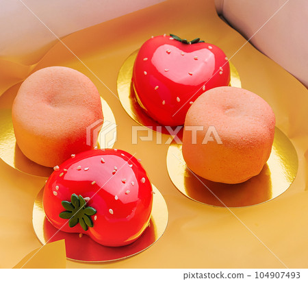 fruit-shaped mousse cakes strawberry and peach in a box 104907493