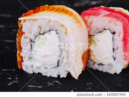 Eel and tuna sushi rolls on stone Eel and tuna sushi rolls on stone 104907495