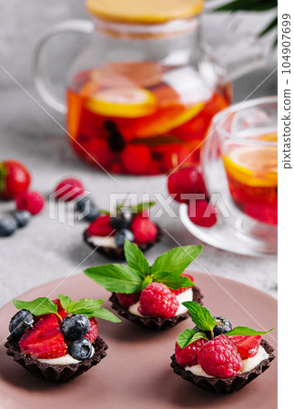 Chocolate ganache tarts with fresh berries 104907699