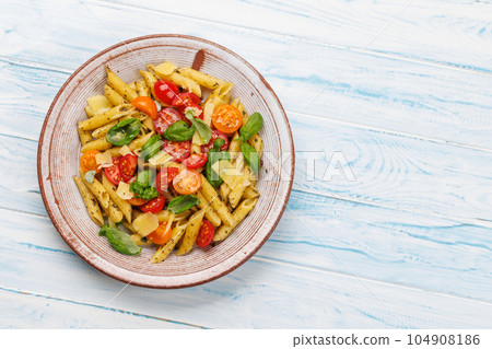 Italian pasta adorned with fresh tomatoes and aromatic basil 104908186