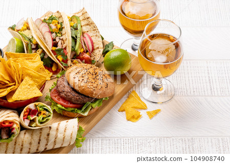 Mexican food featuring tacos, burritos, nachos, burgers Mexican food featuring tacos, burritos, nachos, burgers 104908740