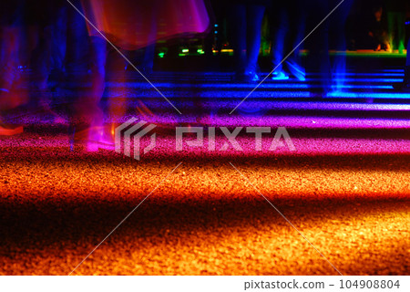 Long exposure shot of feet walking on an illuminated rainbow road in Essen, Germany 104908804