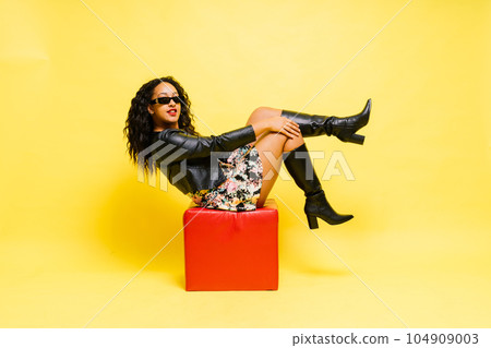 Sensual beautiful african ethnic woman in bodysuit posing in studio isolated on red white background Sensual beautiful african ethnic woman in bodysuit posing in studio isolated on red white background 104909003
