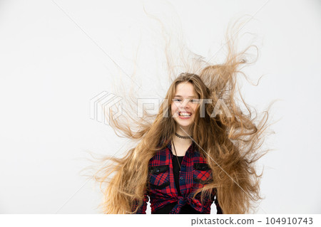 The wind has badly disheveled and tangled the young woman's long hair The wind has badly disheveled and tangled the young woman's long hair 104910743