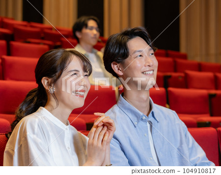 Couple watching a movie with a smile Couple watching a movie with a smile 104910817