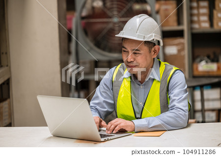 senior adult supervisor engineer male happy worker work in factory products parts storage. inventory manager control hardware storage by laptop software senior adult supervisor engineer male happy worker work in factory products parts storage. inventory manager control hardware storage by laptop software 104911286