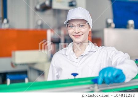 Happy teen young women worker in conveyor belt production line in food and beverage factory with employee white hygiene clothes 104911288