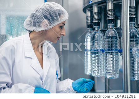 worker in drinking water factory. women workers caucasian labor in beverage clean production conveyor belt mineral water manufactory. 104911291