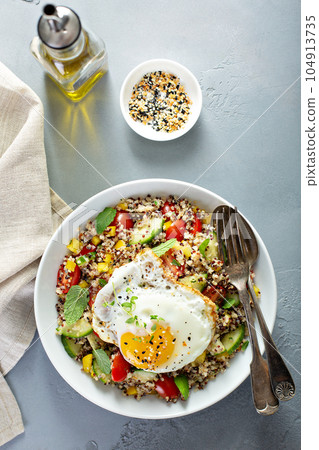 Fresh quinoa tabbouleh salad with fried egg 104913735